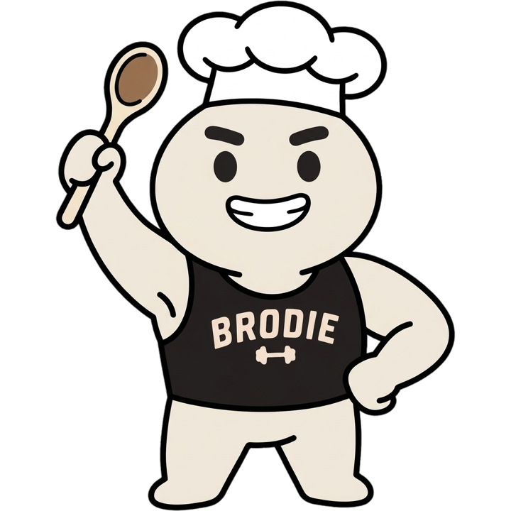 Brodie in a chef's hat holding a wooden spoon up